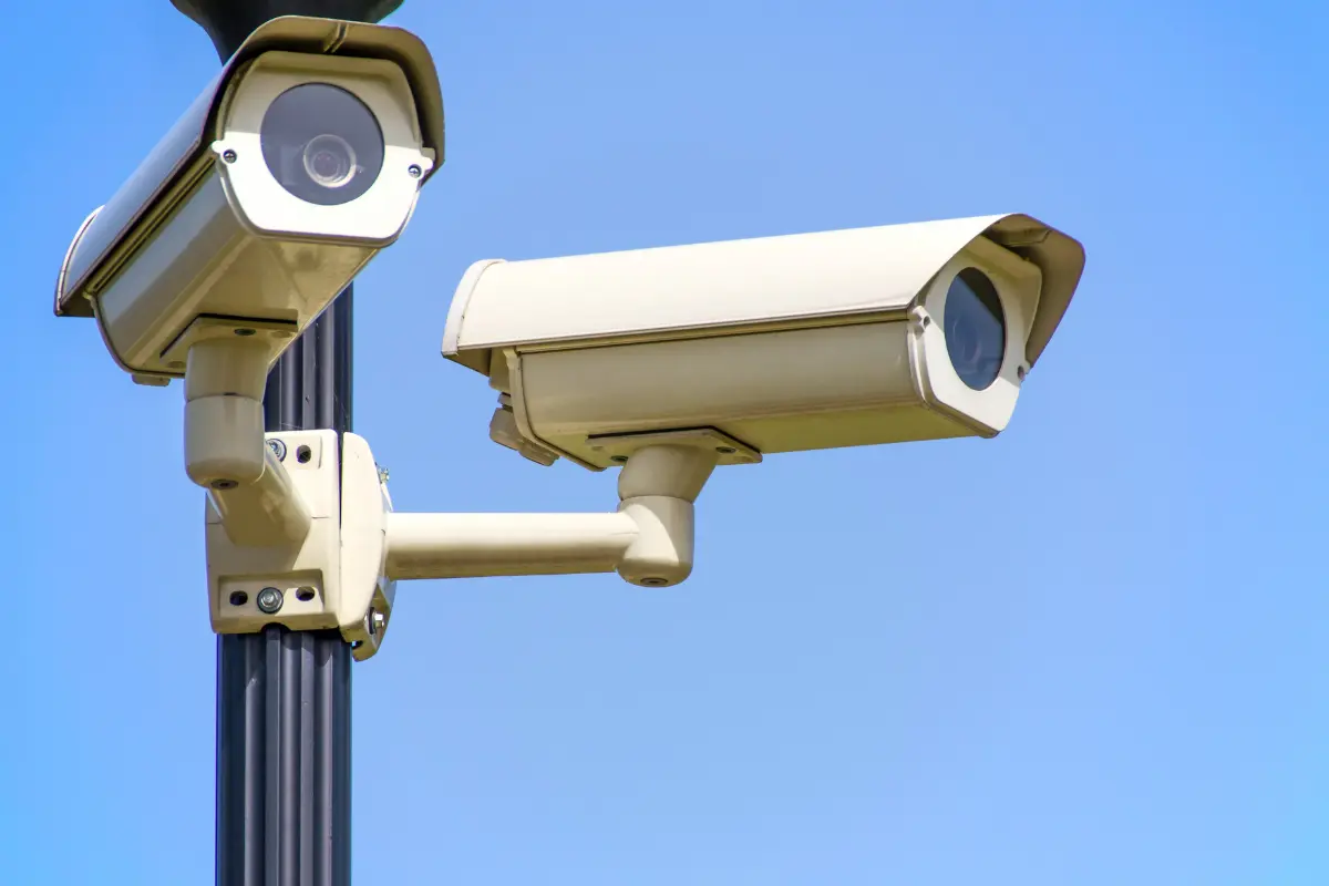 Close em câmera de vigilância em funcionamento, reforçando a ideia de vigilância constante. Foto: Reprodução / Canva Pro.